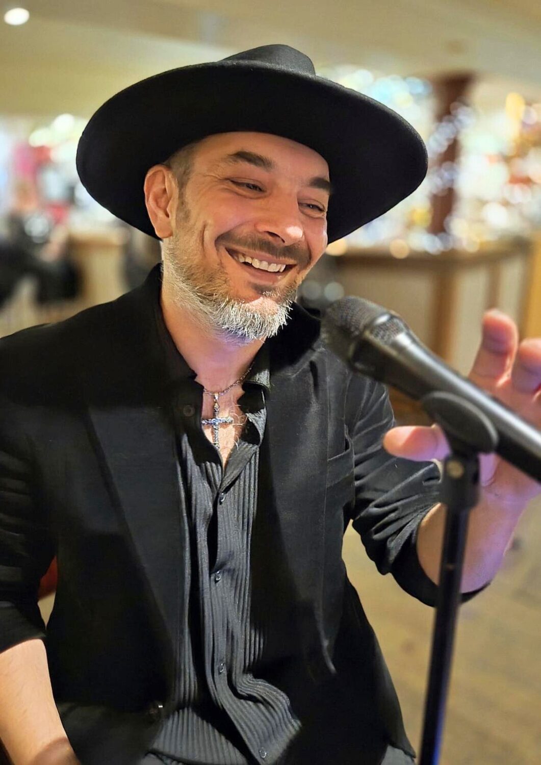 Robbie Sczabo, the Transylvanian Crooner, singing at the microphone in a black hat